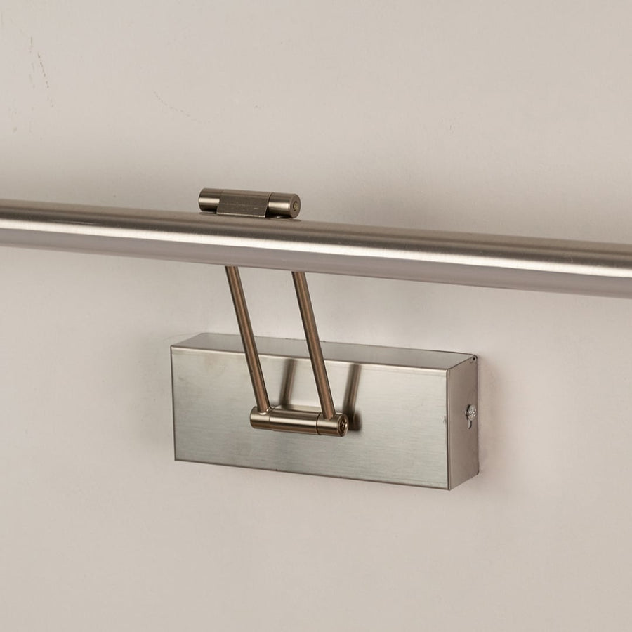 Closeup view of silver picture light highlighting smooth metal body and adjustable arm for focused picture and wall lighting.