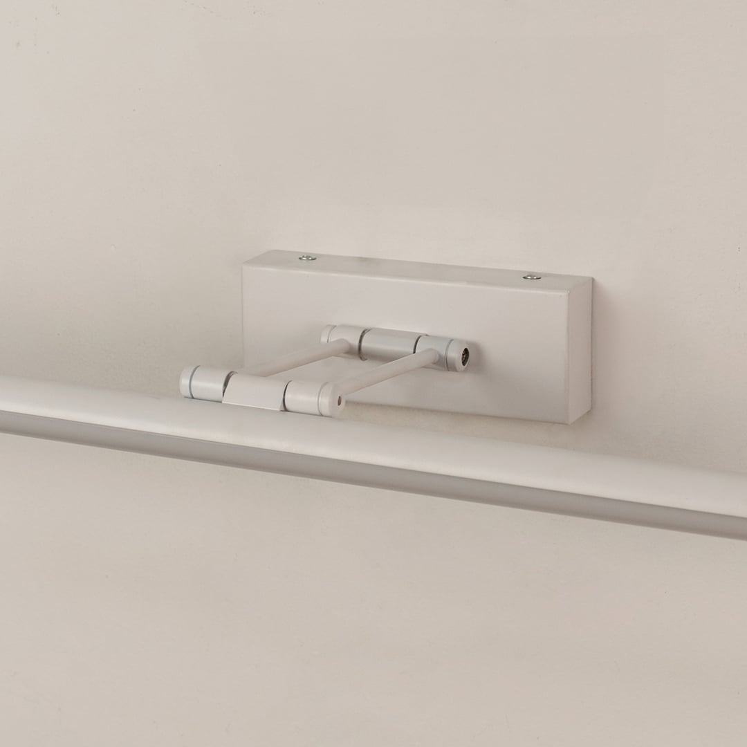Closeup of white adjustable picture light showing sleek metal body and smooth modern wall mounted design.