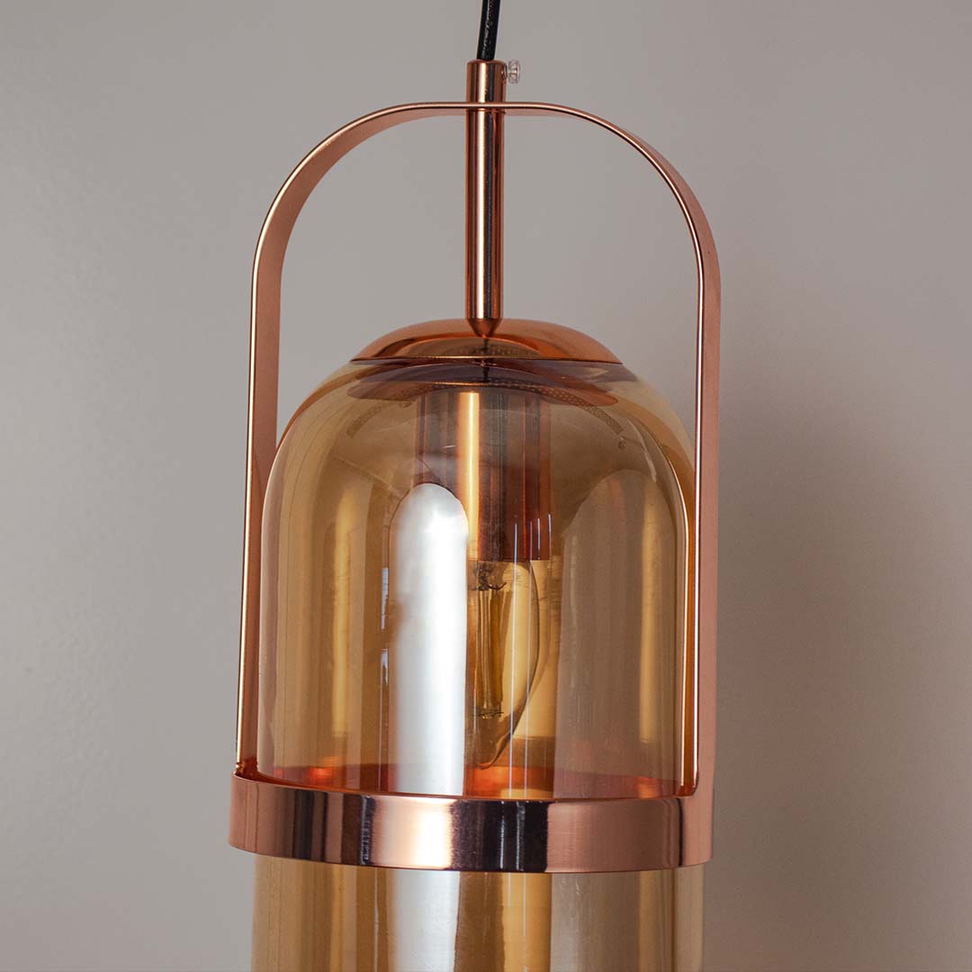 Close view of amber glass pendant lamp with gold frame showing fine detailing and premium modern lighting design.