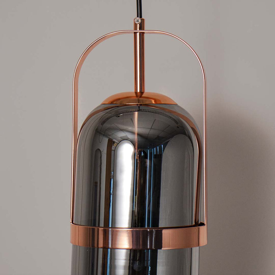 Detailed closeup of smoked glass pendant lamp with copper finish showing fine craftsmanship and texture.