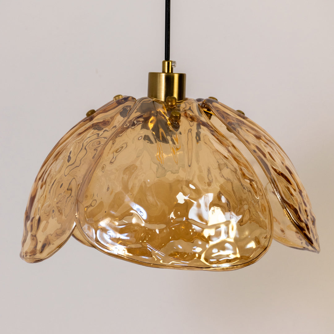 Contemporary pendant light in gold metal finish with textured glass shade for dining room or kitchen decor lighting white background.