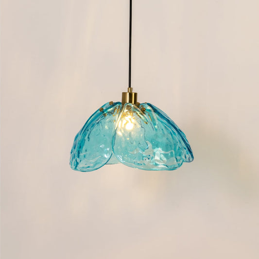 Blue textured glass and gold metal pendant light with warm glow for elegant dining room and kitchen decor interiors styling.