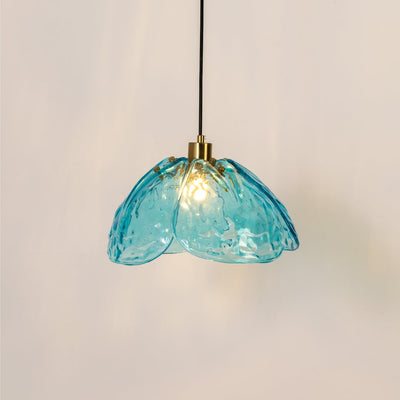 Blue textured glass and gold metal pendant light with warm glow for elegant dining room and kitchen decor interiors styling.