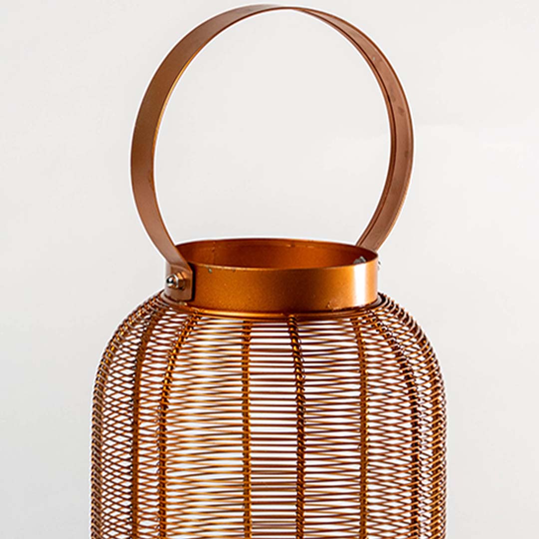 Closeup of copper metal mesh lantern with round handle for modern tabletop decor styling use.