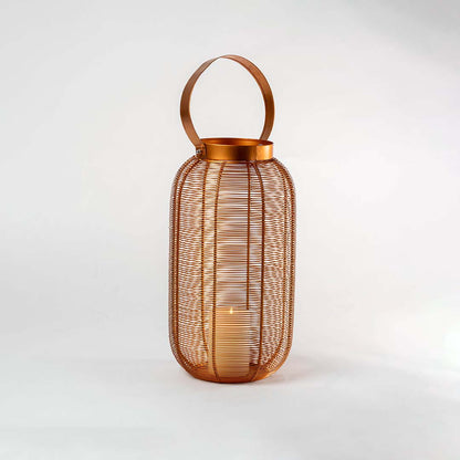 Illuminated copper metal wire lantern with round handle and glowing candle light inside on clean white studio background.