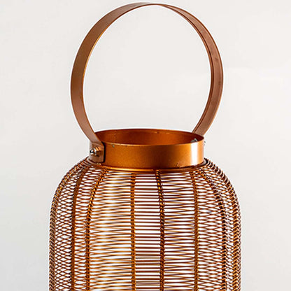 Closeup detail of copper metal wire mesh ribbed texture and circular handle attachment on decorative candle lantern holder.