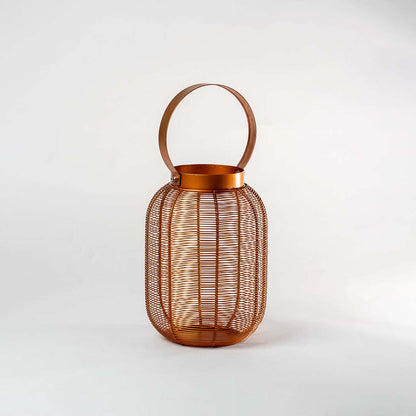 Copper metal mesh cylindrical lantern with circular carrying handle and ribbed texture design on isolated white background.