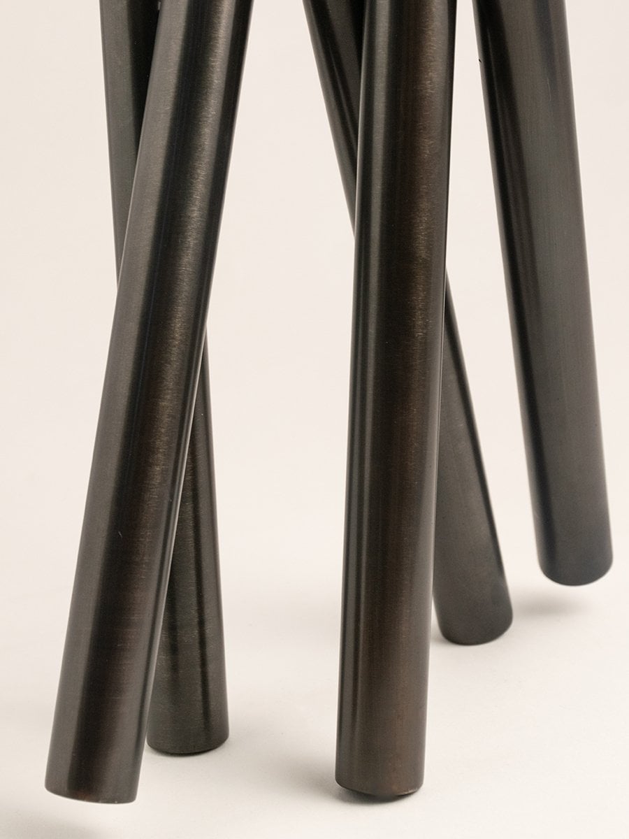 Detailed view of tubular black metal vase design with polished finish and clean lines.