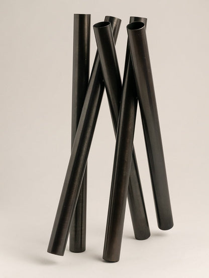 Matte black metal vase with tubular shape on a white background creating a minimalist and contemporary appeal.