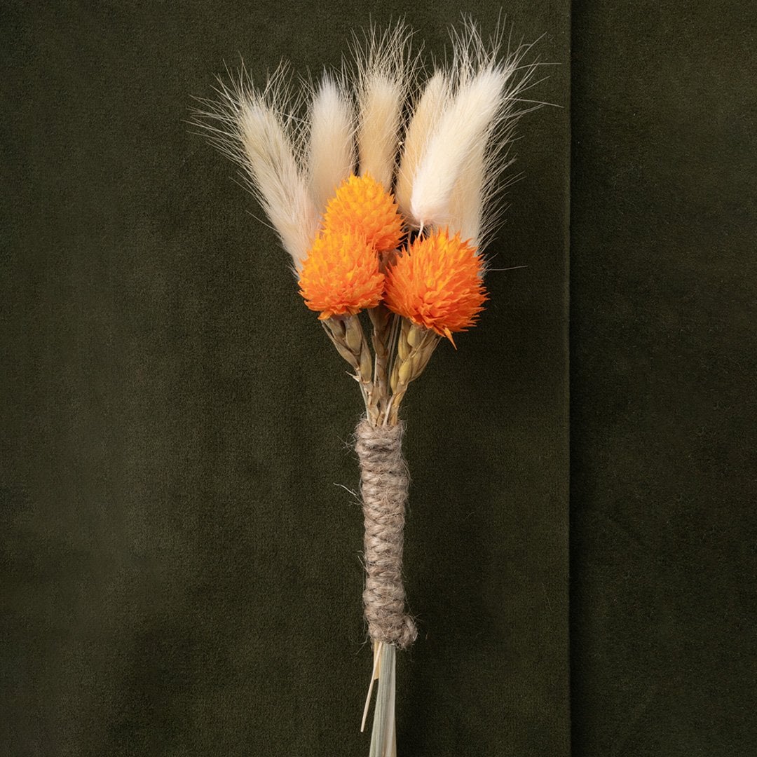 Rustic boutonniere with orange dried flowers natural preserved stems and jute wrap ideal for groom and groomsmen wedding wear.