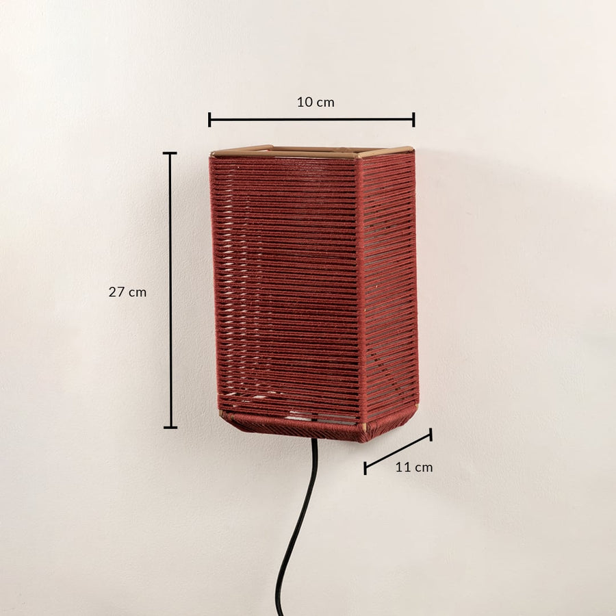 Rectangular rust red woven wall light fixture displaying a height of twenty-seven centimeters on a plain background.