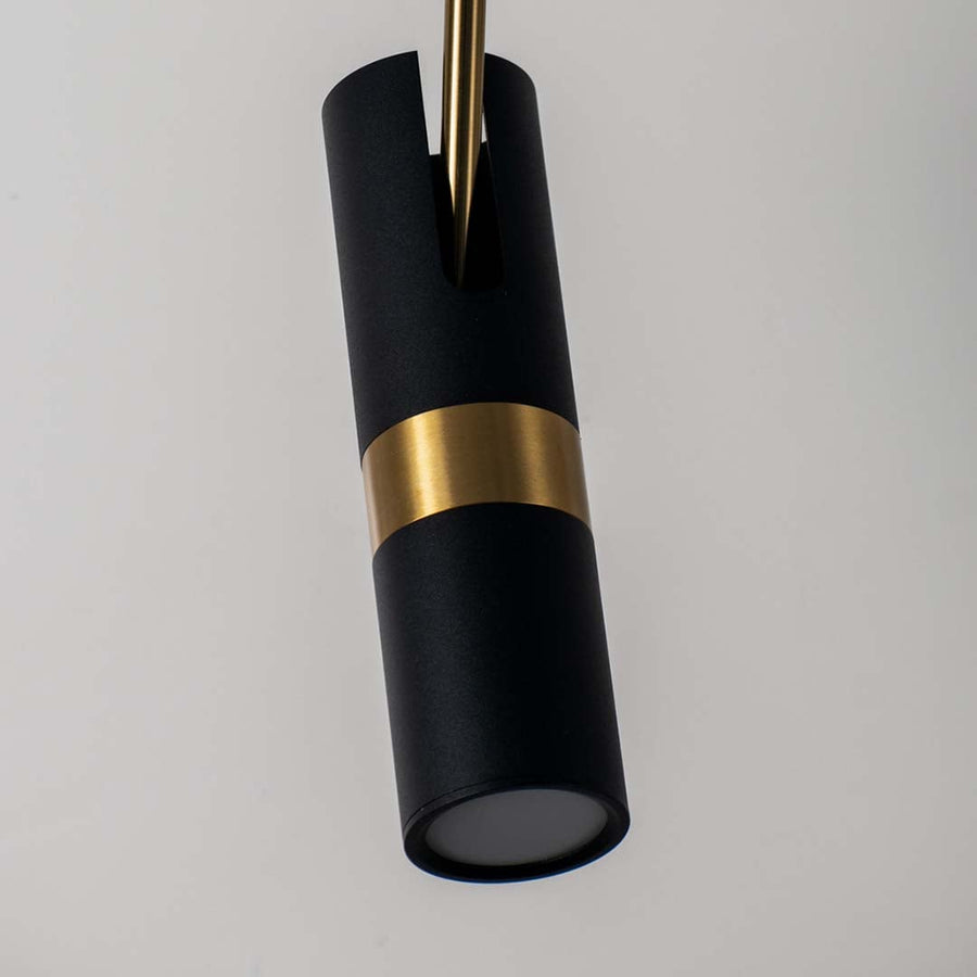 Closeup of modern black and gold cylindrical pendant lamp with matte finish stylish ceiling light for luxury home interiors.