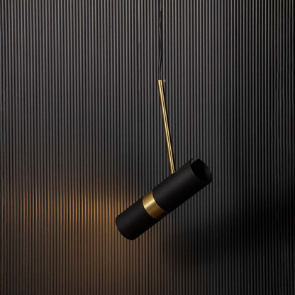 Modern black and gold cylindrical pendant lamp glowing warm light elegant ceiling fixture for bedroom and luxury home styling.