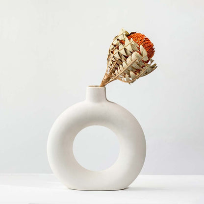 Dried orange protea stem styled naturally for warm earthy home decor accents shown against a clean light background.