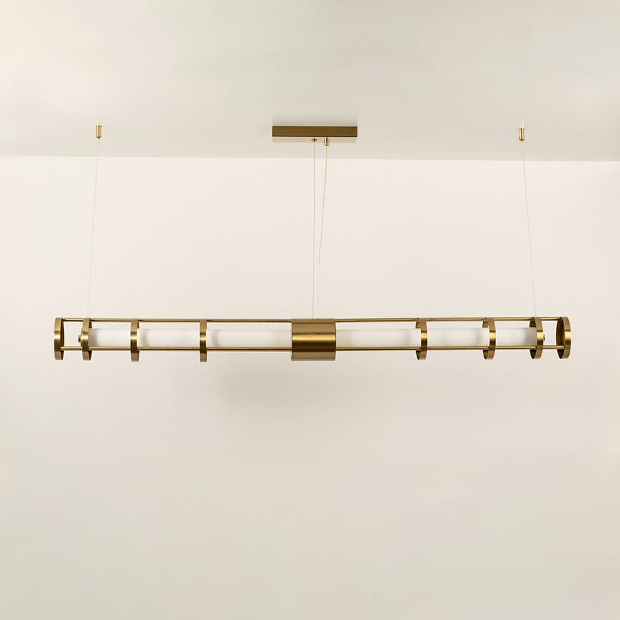 A gold linear ceiling fixture with symmetrical cylindrical elements ideal for modern LED chandelier lighting and luxury designer interior décor applications.