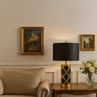 Black and gold ceramic table lamp with fabric shade placed on wooden console adding luxury to modern living decor.