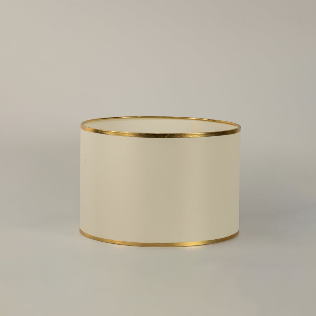 White round drum lamp shade with gold trim shown in close up view on plain background for elegant modern lighting décor.