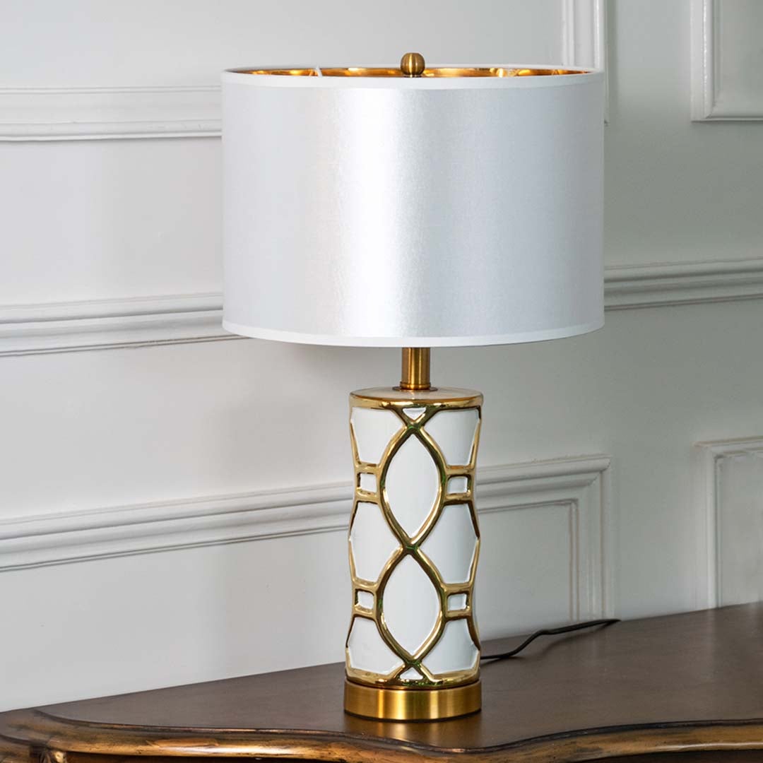 White and gold ceramic table lamp with fabric shade displayed unlit on white background for sophisticated decor.