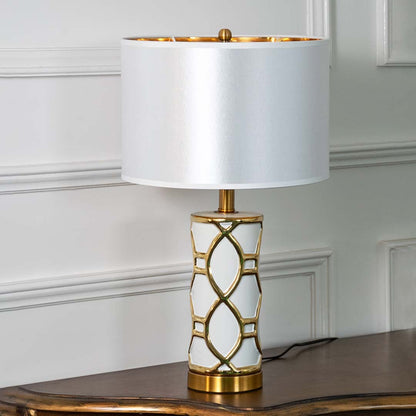 White and gold ceramic table lamp with fabric shade displayed unlit on white background for sophisticated decor.
