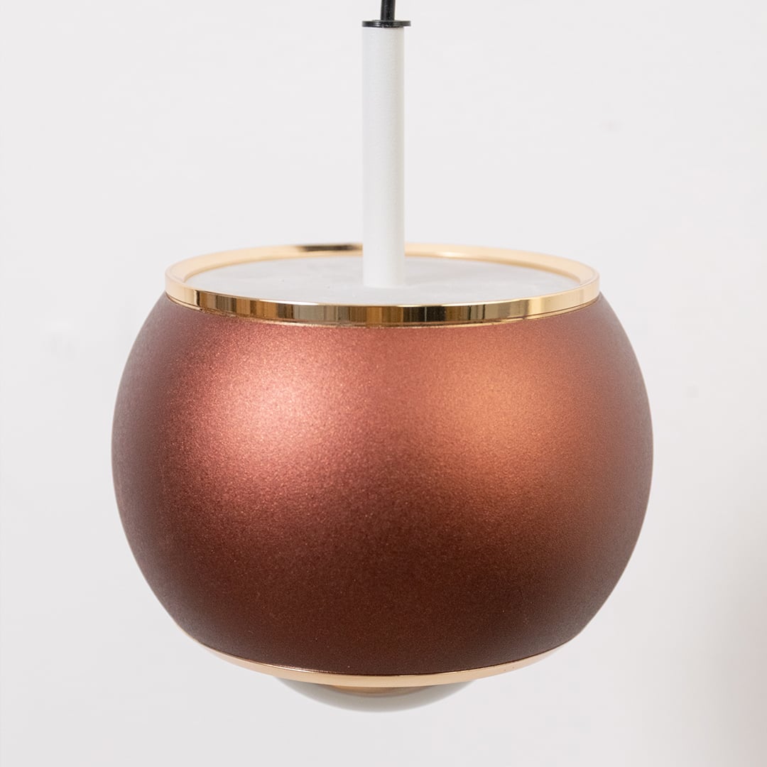 Closeup of brown pendant wall light showing round metallic finish and sleek modern design.
