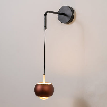 Modern black and brass pendant wall light with warm glow for elegant bedroom interior decor.