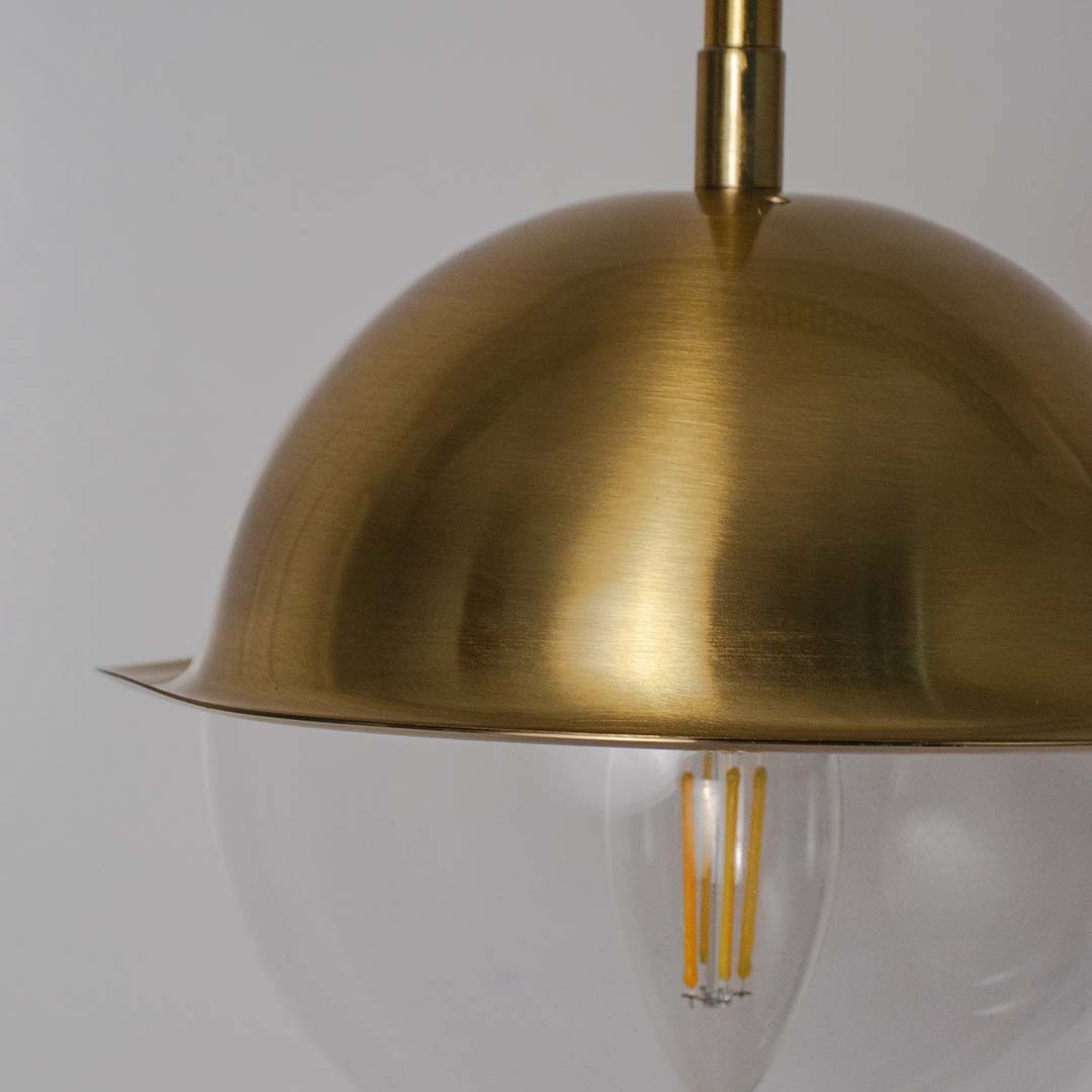 Closeup of brushed brass pendant light showcasing refined curves and premium craftsmanship details.