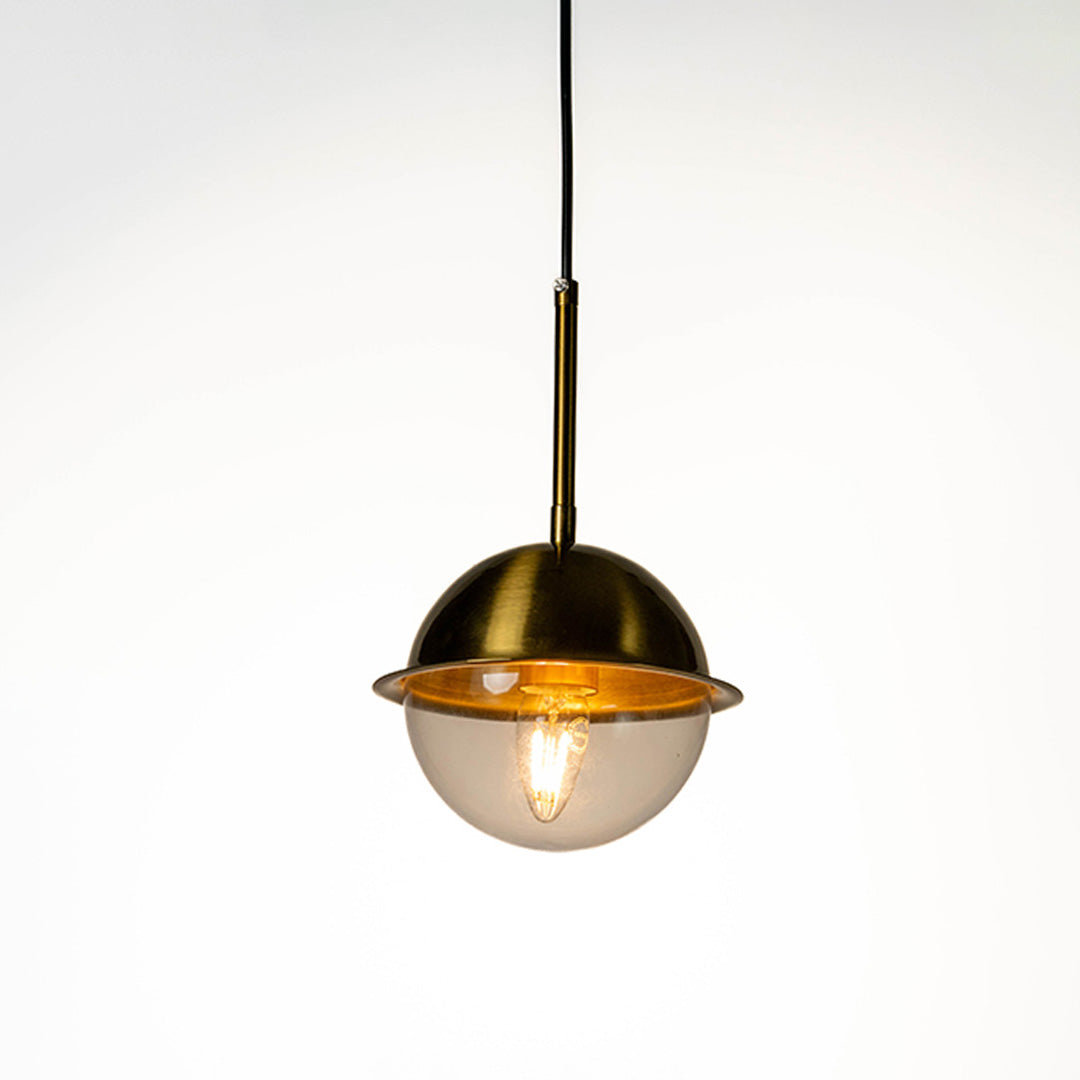 Modern pendant light with gold and white dome shade and hanging cord placed against neutral wall background showcasing elegant contemporary lighting decor styling.