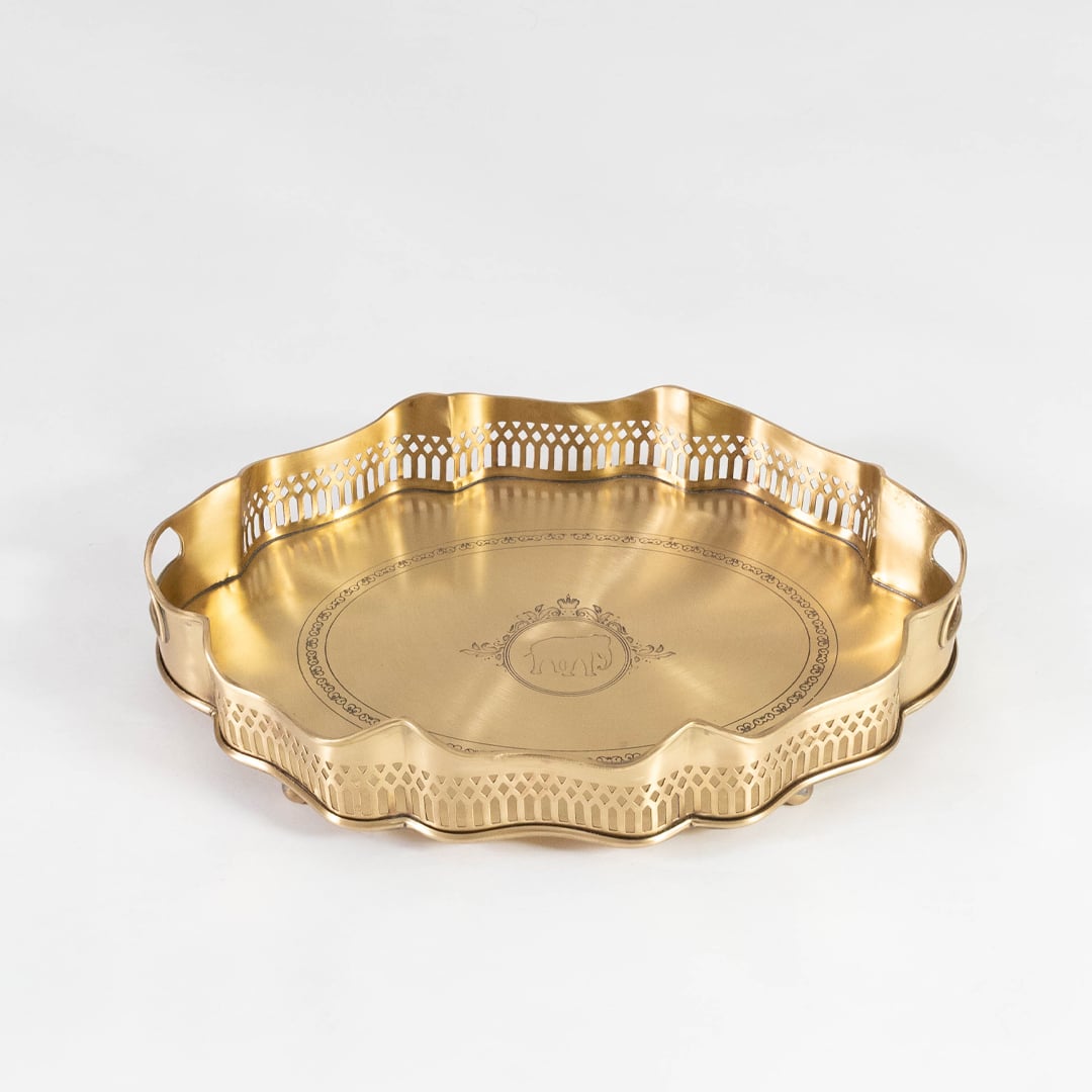 Flat brass tray with decorative rim and side engravings shown in front view against a clean white backdrop.