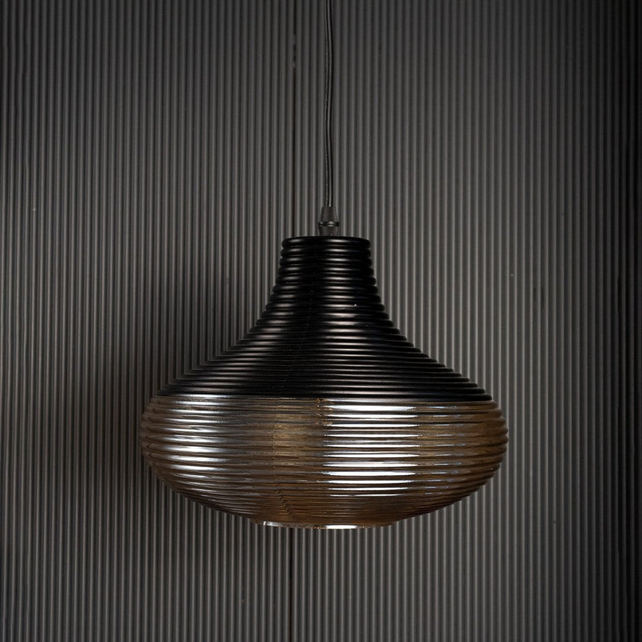 Red glass pendant light with gold cap shown against black background perfect for adding elegance to modern spaces.