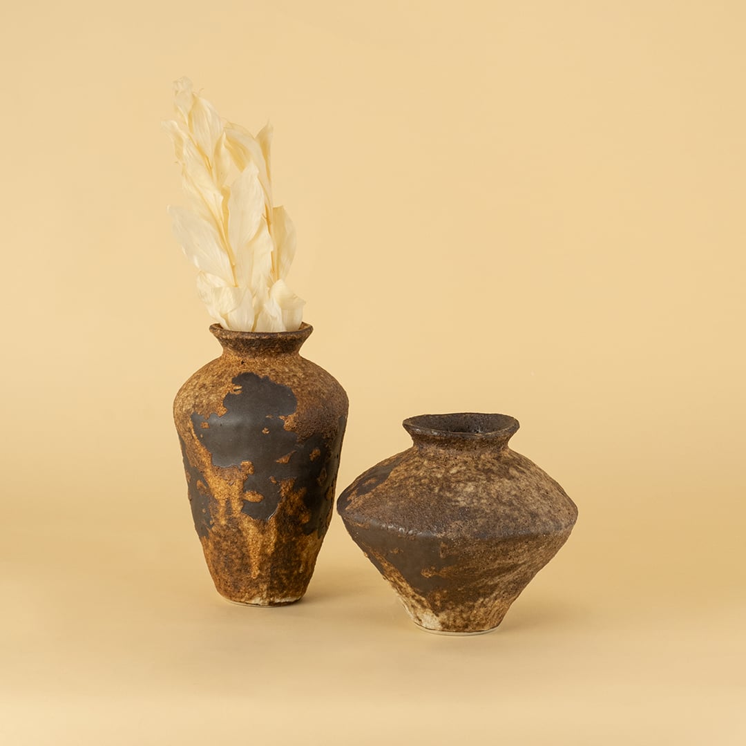 Set of rustic brown ceramic vases in varied shapes styled together creating artistic earthy home decor display