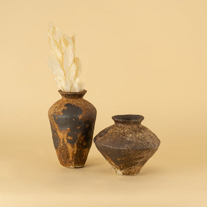 Set of rustic brown ceramic vases in varied shapes styled together creating artistic earthy home decor display
