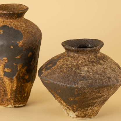 Closeup of grouped rustic brown ceramic vases highlighting handmade texture and organic earthy color variation.