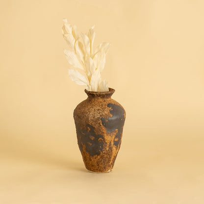 Tall rustic brown ceramic vase with textured finish styled on wooden table adding earthy charm to home interior decor
