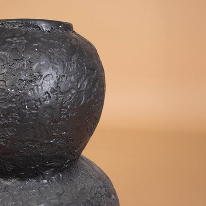 Closeup of black textured decorative vase showing detailed handcrafted surface ideal for adding modern artistic style to home interiors.