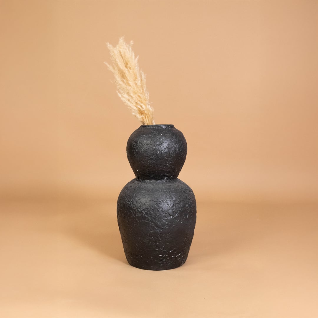 Black textured decorative vase placed in a warm styled interior adding bold artistic character to shelves consoles and living room decor.