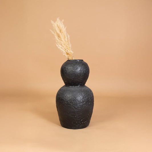 Black textured decorative vase placed in a warm styled interior adding bold artistic character to shelves consoles and living room decor.