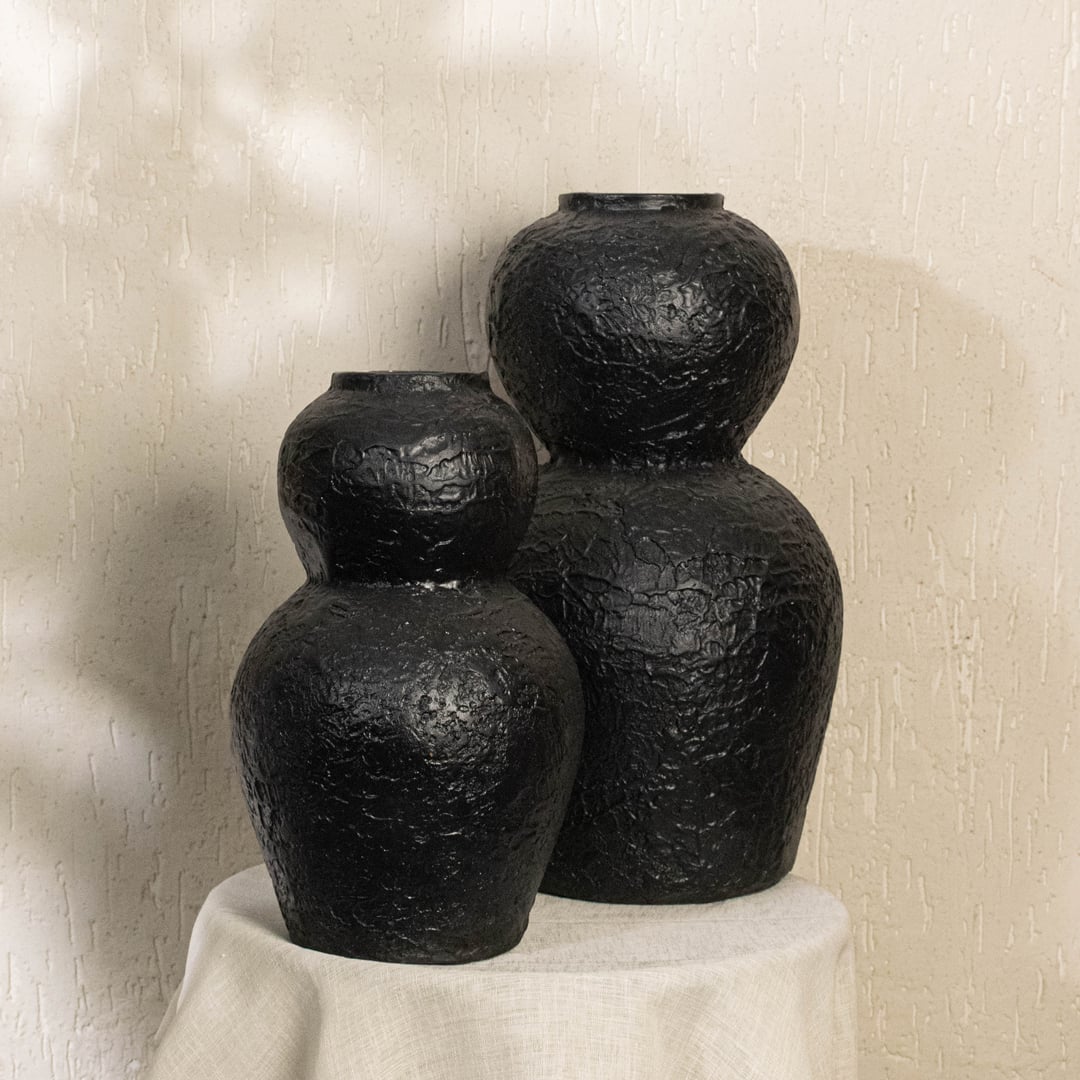 Black textured decorative vase styled in a modern room adding bold artistic decor to living rooms hallways and contemporary interior spaces.