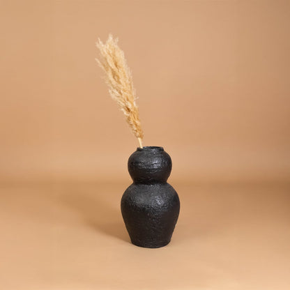 Black textured decorative vase placed in a modern styled room adding bold artistic decor to shelves consoles and warm interior spaces.