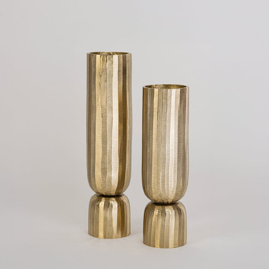 Elegant tall gold vase with fluted body featured in styled interior space for floral display or modern decorative touch.