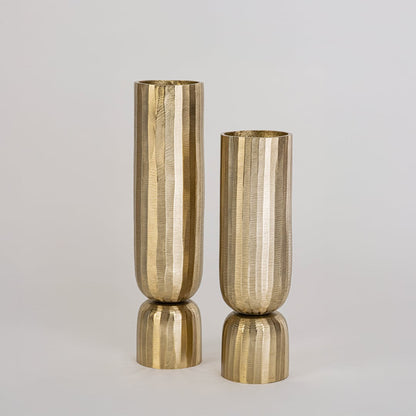 Elegant gold vase with sculptural form shown in interior space for table centerpiece or modern accent decor setup