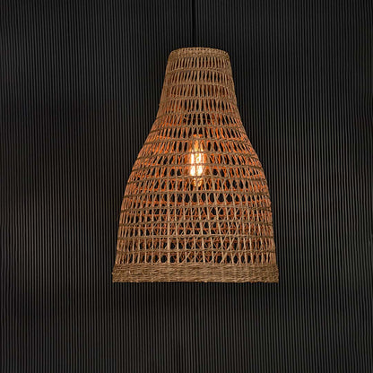 Natural rattan pendant lamp with woven detail illuminated on back background for elegant boho and cafe ceiling decor.
