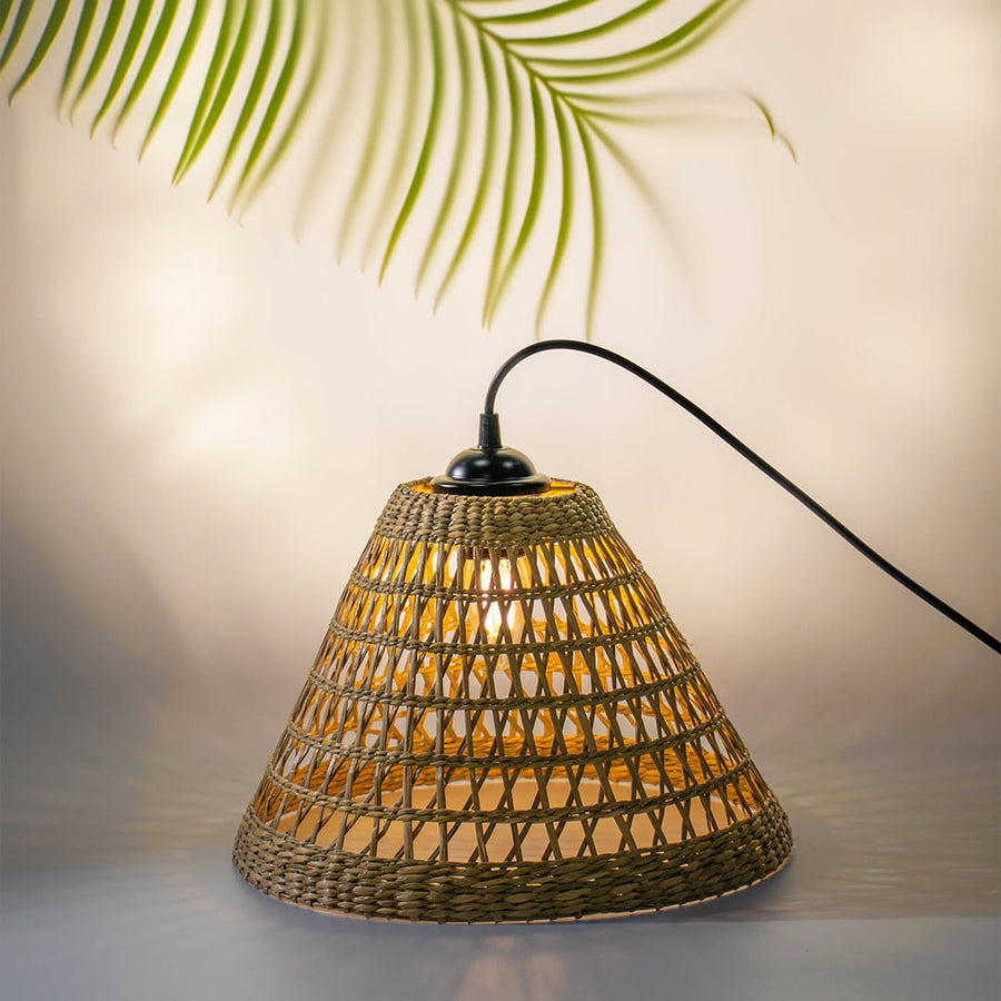 Conical rattan pendant light with woven shade styled in cozy interior for rustic dining and living room lighting.