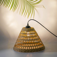 Handwoven rattan table lamp with black curved arm creating warm bohemian lighting and natural charm.
