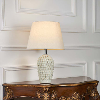 Ceramic table lamp with blue patterns and a glowing light styled on a bright white background creating a clean premium product display.