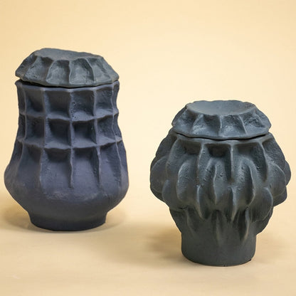 Set of sculptural black ceramic vases arranged together against white background highlighting artistic craftsmanship and modern design appeal.