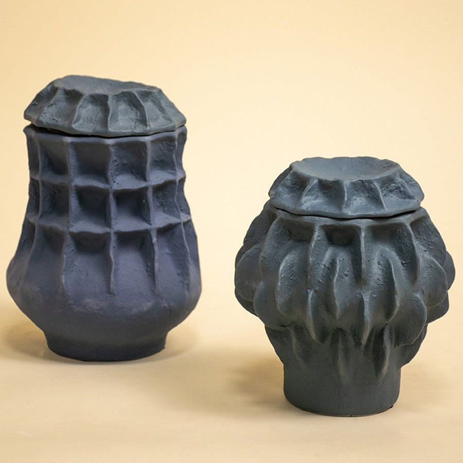 Set of sculptural black ceramic vases arranged together against white background highlighting artistic craftsmanship and modern design appeal.