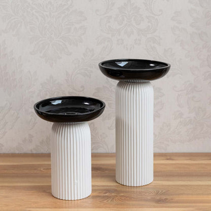 Set of dual-tone ceramic vases featuring black glossy tops and ribbed white bases for modern home styling.