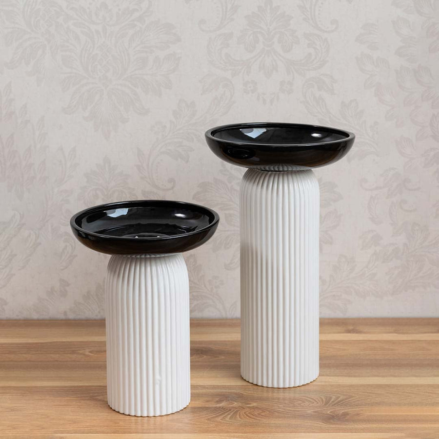 Set of dual-tone ceramic vases featuring black glossy tops and ribbed white bases for modern home styling.