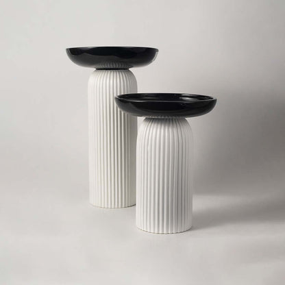 A stylish pedestal bowl in black and white shown in a grouped decor setup adding a bold contemporary touch to modern home styling.