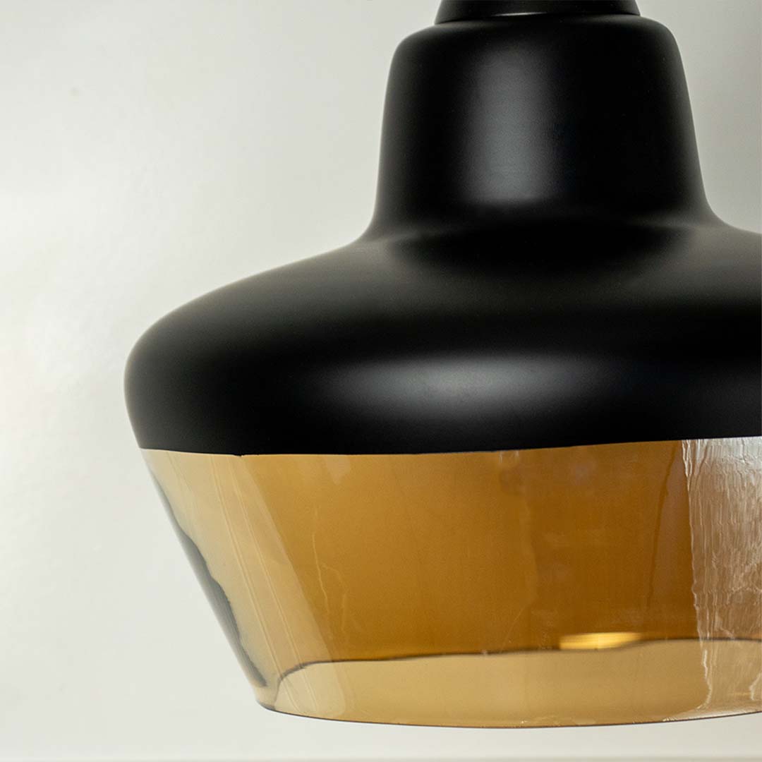 Closeup of contemporary black and amber glass pendant lamp with sleek finish perfect for modern home lighting decor.